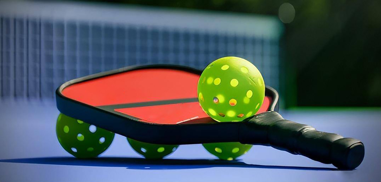 Custom pickleball paddles showing varied graphics, grips, materials, and weight-balance options